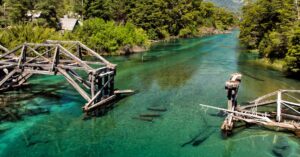 A picturesque broken bridge over a turquoise river in San Martín de los Andes, Argentina.